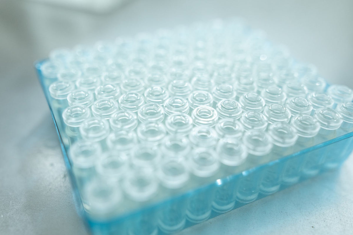 Close-up van doorzichtige laboratoriumvials in een blauw laboratoriumrek.
