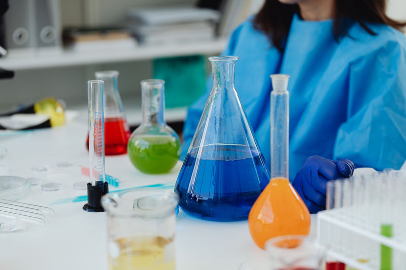 Laboratoriumglaswerk met gekleurde oplossingen op een werkbank